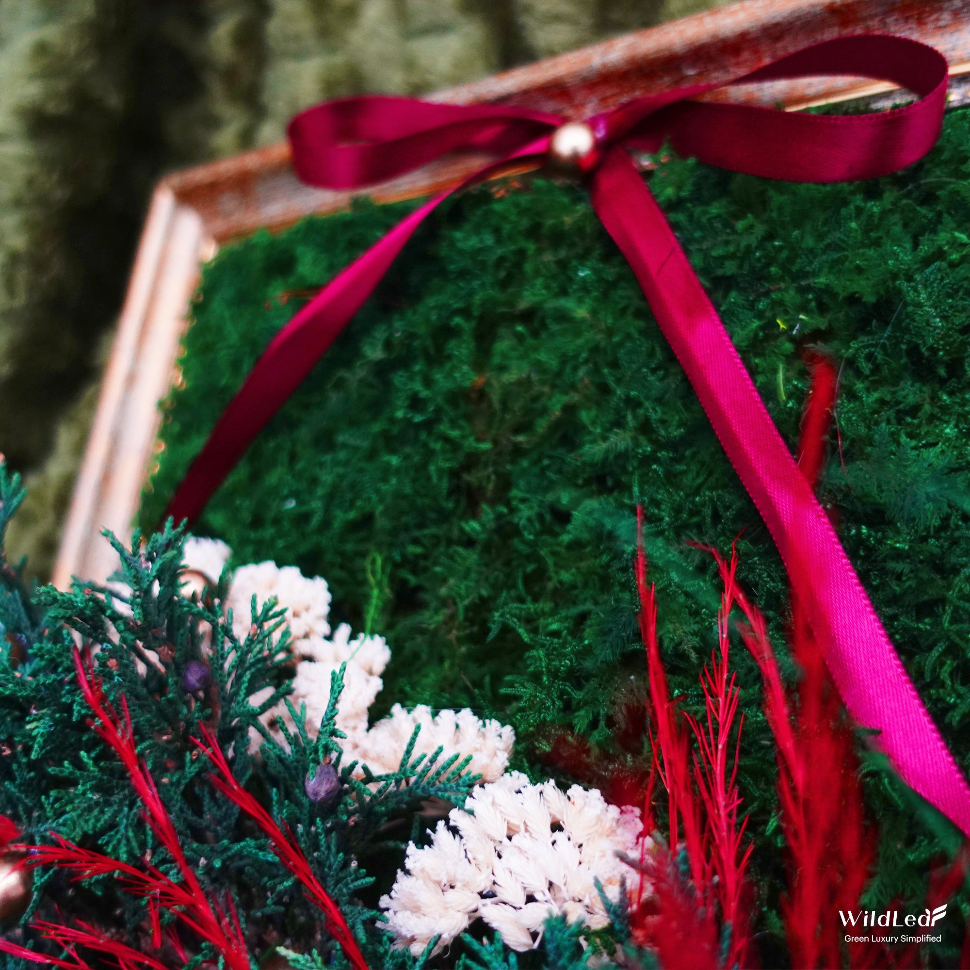 Close-up of Vintage Framed Christmas Moss Wall Art, showcasing burgundy ribbons and preserved green moss.