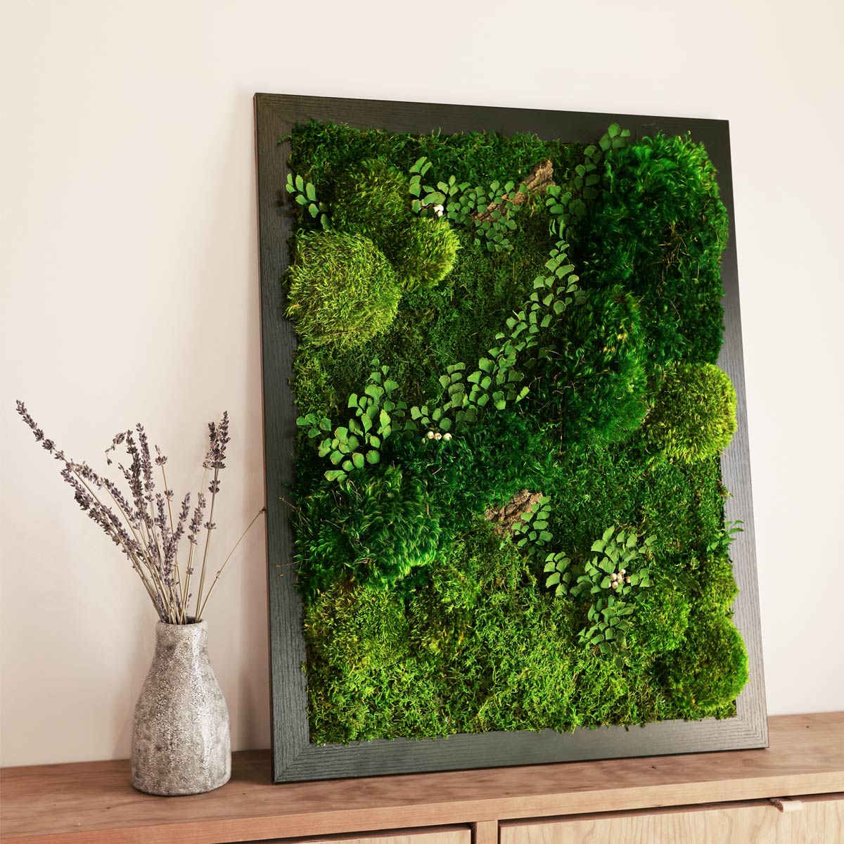 Side view of framed organic moss panels showing depth and frame detail