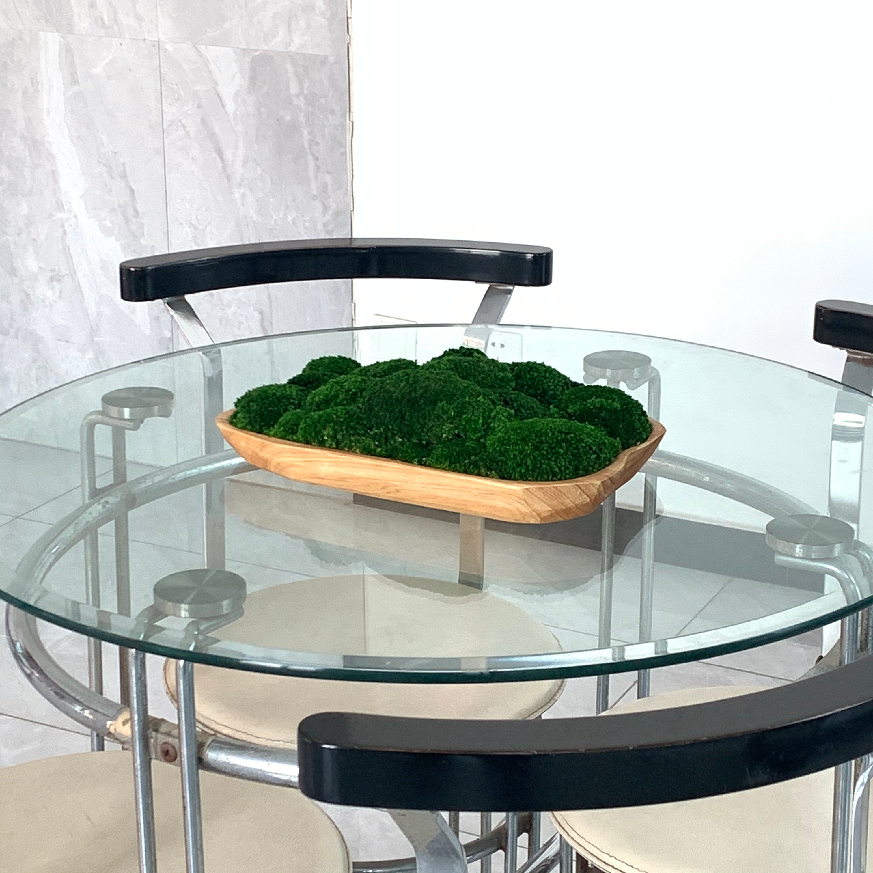 Unique wooden moss bowl as focal point in contemporary cafe setting.