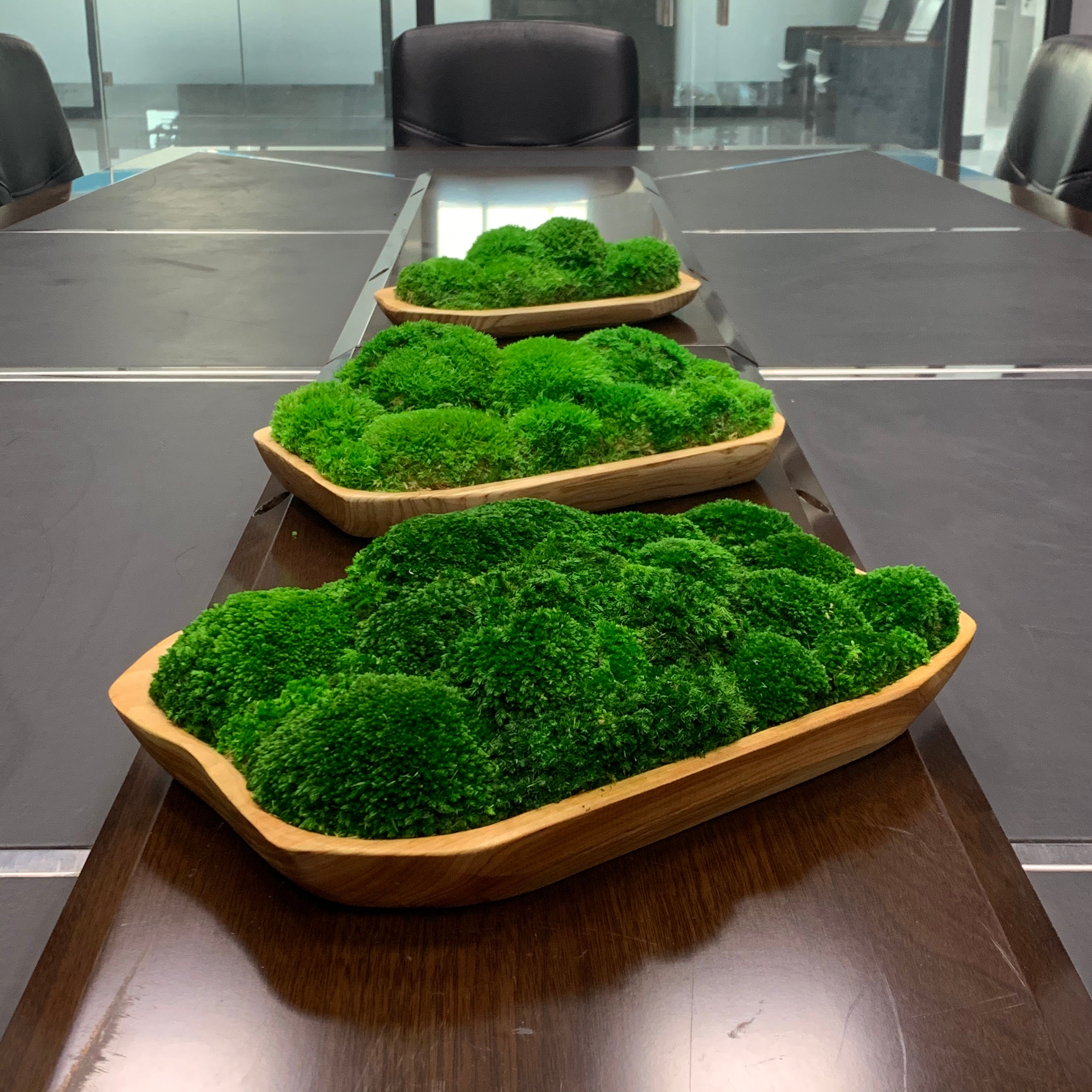Three live edge moss bowl centerpieces styled on conference room table.