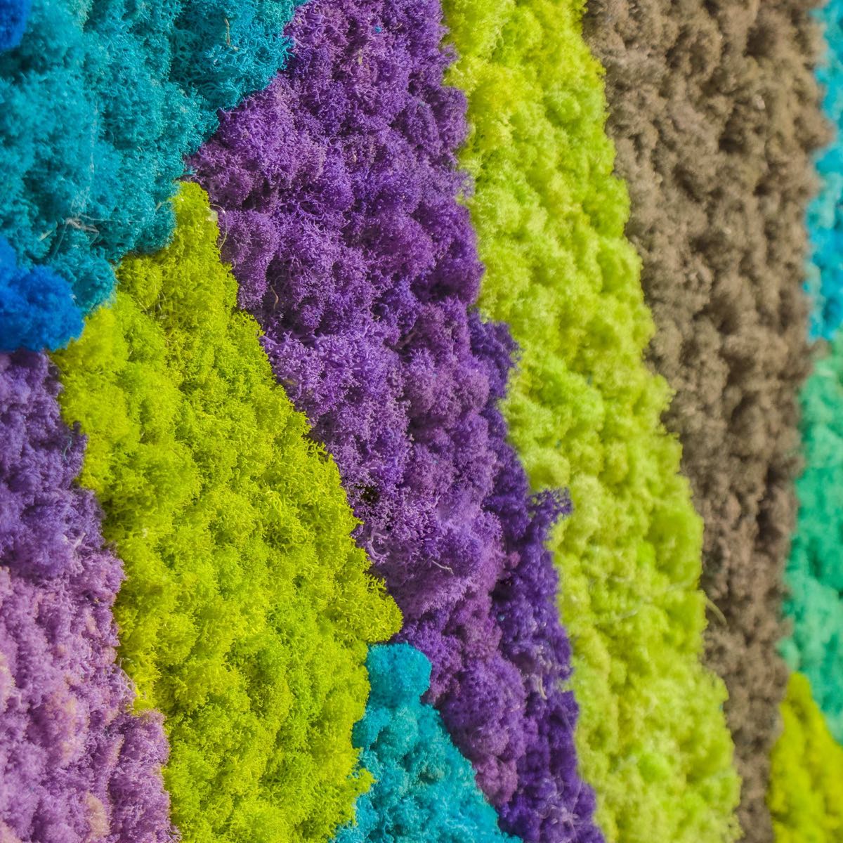 Close-up of abstract reindeer moss wall art featuring cool-toned layers in blue, purple, green, and gray with rich natural texture.