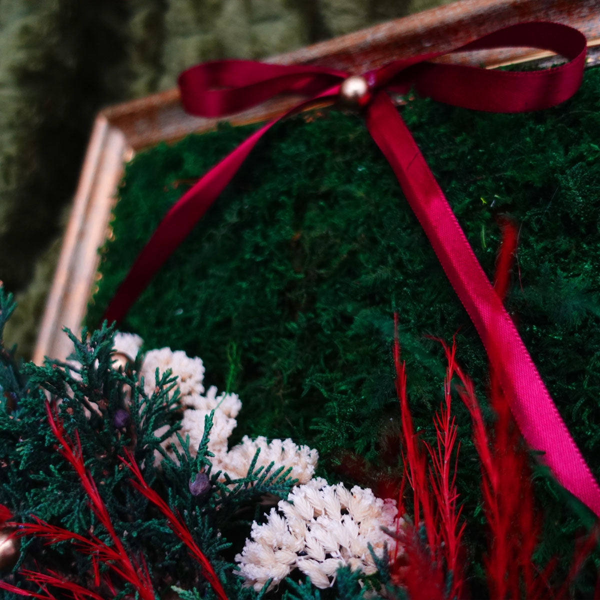 Antique gold framed Christmas moss wall art detail featuring preserved green moss, red ribbon, pine branches, and festive holiday accents.