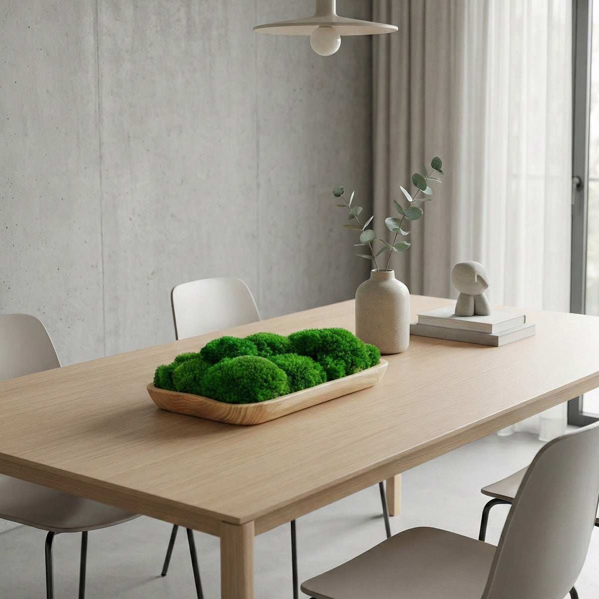 Live edge natural wooden moss bowl with preserved green moss displayed on a minimalist dining table in a modern interior setting.