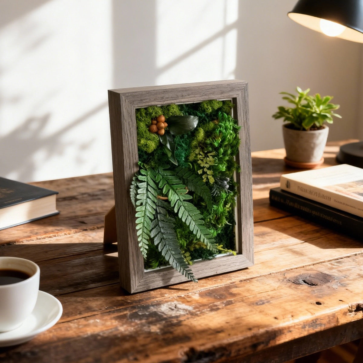 Walnut Lush Moss Table Frame standing on a wooden desk in a warm, sunlit home workspace.