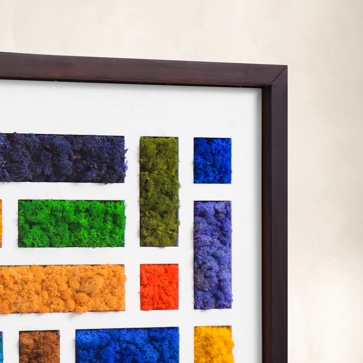 Close-up detail of Mondrian-inspired reindeer moss art featuring textured geometric color blocks in blue, green, orange, and yellow within a walnut frame.